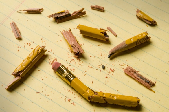 Broken pencil fragments on yellow paper
